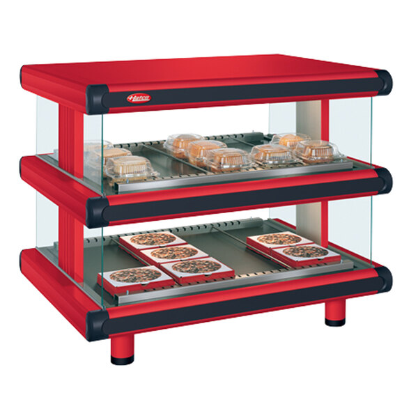 A red and black Hatco warm food display case on a counter with trays of food.