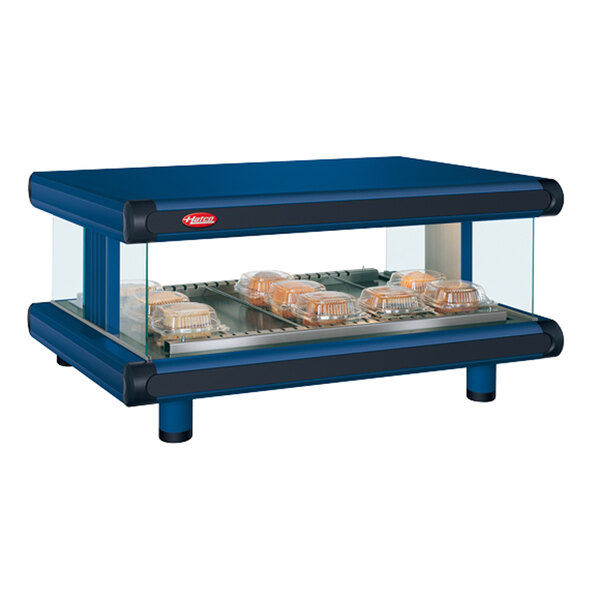 A navy blue Hatco food warmer with trays of food on a counter.