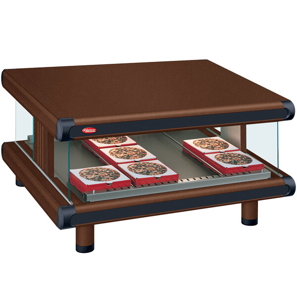 A Hatco copper countertop display case with trays of pizza.