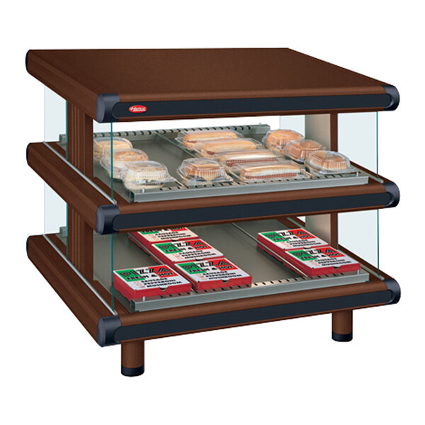 A Hatco countertop display case with two slanted shelves and a glass door filled with food.
