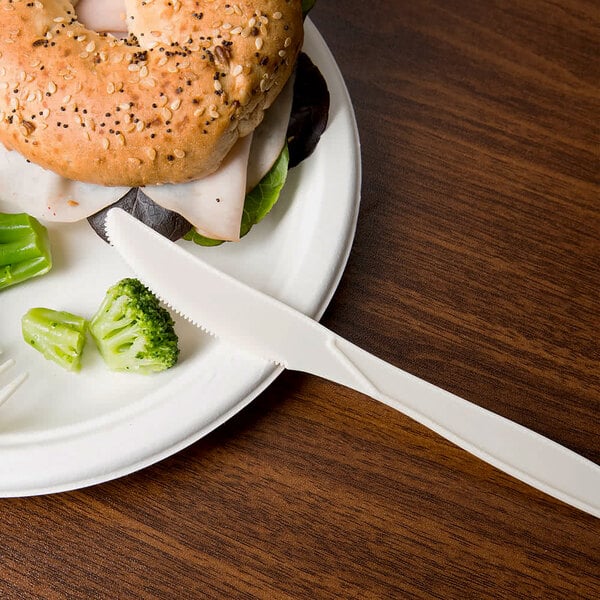 An 8" heavy weight cornstarch knife on a white plate with a sandwich and broccoli.