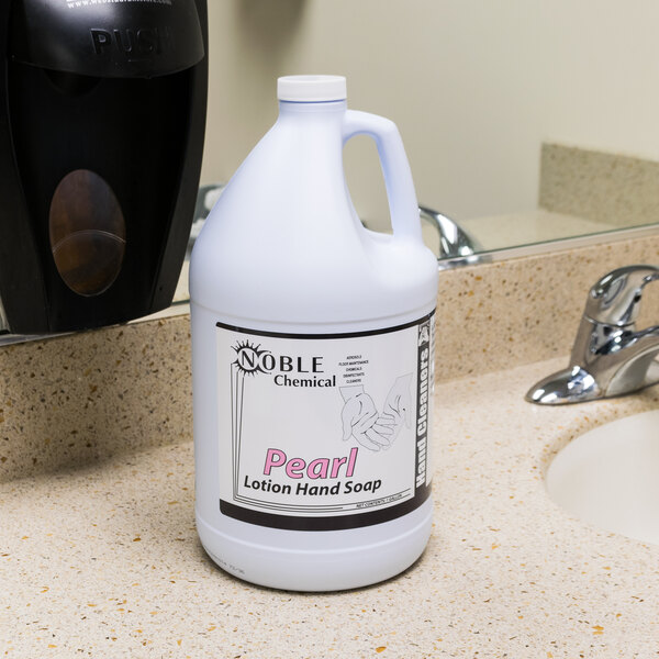A white bottle of Noble Chemical Pearl lotion hand soap on a counter.