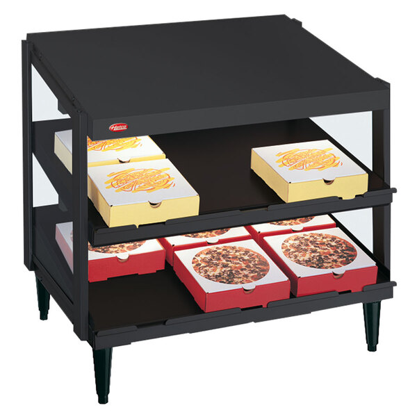 A black Hatco countertop pizza warmer display with pizza boxes on shelves.