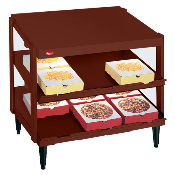 A Hatco pizza warmer shelf with pizza boxes on it.