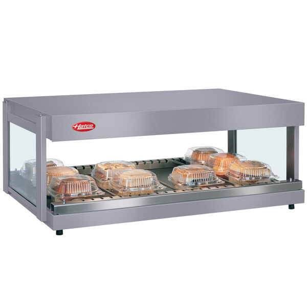 A Hatco countertop food warmer with food on a tray in a glass case.
