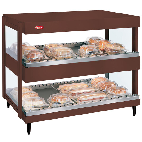 A Hatco countertop display case with trays of food on shelves.