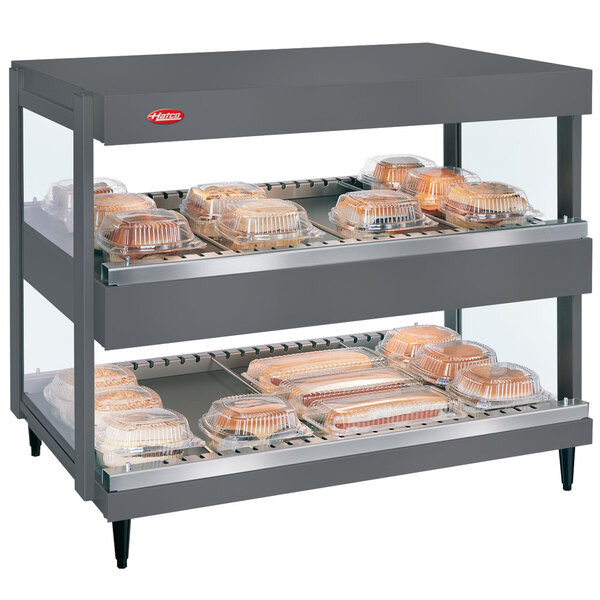 A Hatco countertop display case with food trays on shelves.