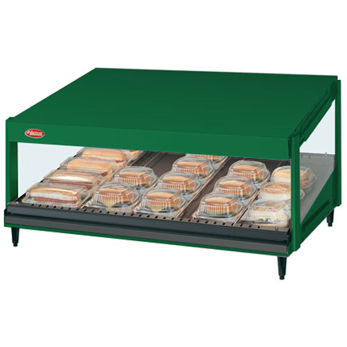 A green Hatco countertop display case with trays of food.