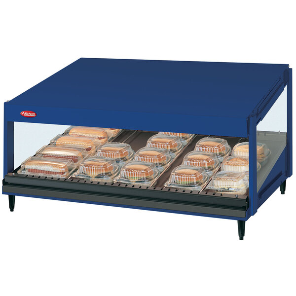 A blue Hatco countertop display case with food on a slanted shelf.