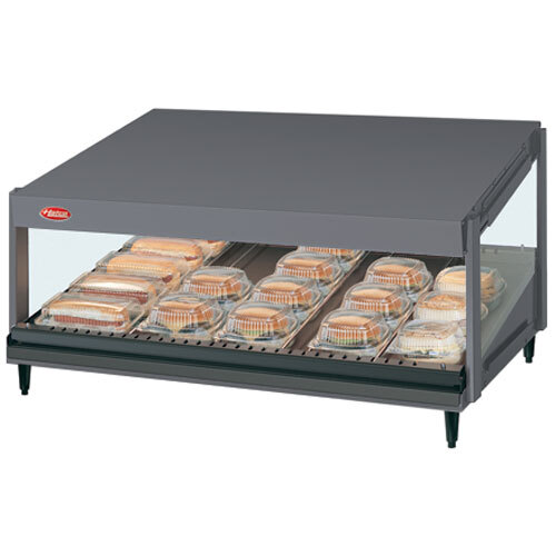 A Hatco countertop food warmer with trays of food on a shelf.