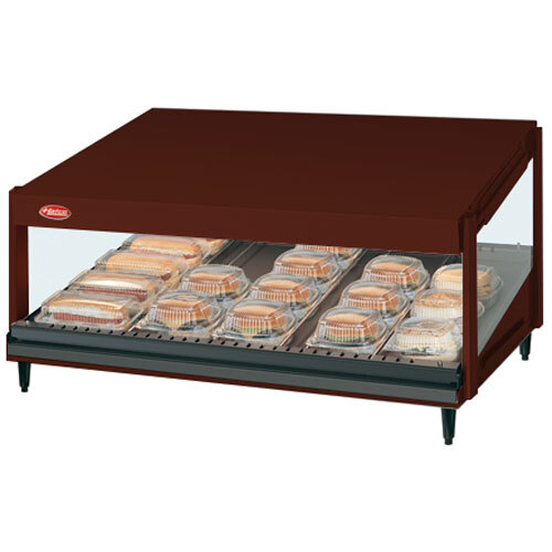 A Hatco Antique Copper countertop food warmer with food on a slanted shelf.