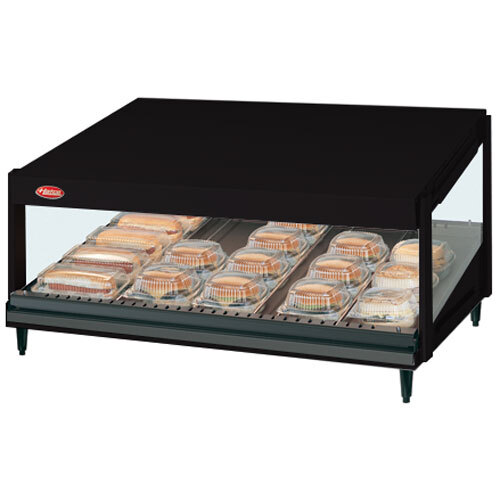 A black Hatco countertop display case with a slanted shelf holding trays of food.