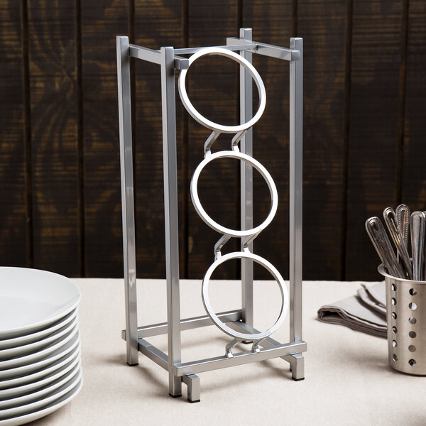 A metal rack with three vertical cylinders on it.