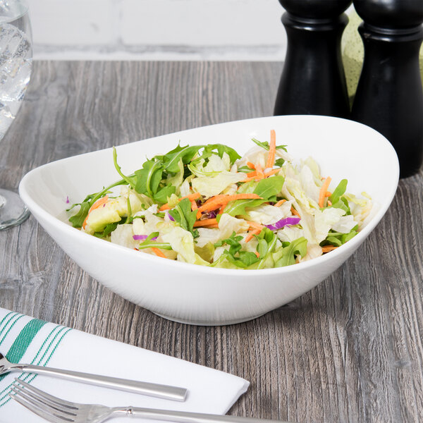 A Tuxton Capistrano bowl filled with salad on a table.