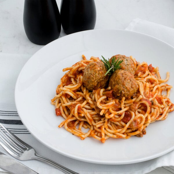 A plate of spaghetti with meatballs and a fork.