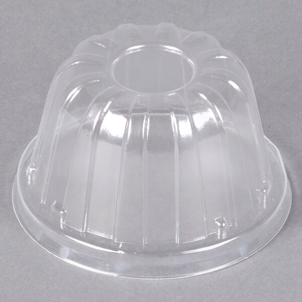 A clear plastic high dome lid on a white surface.