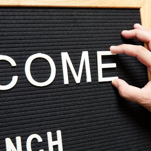 A person using an Aarco Helvetica letter board to display the words "Welcome Lunch"