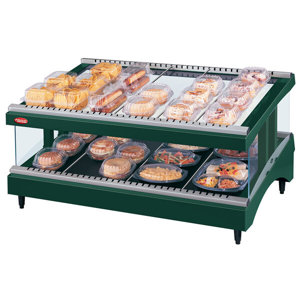 A Hunter Green Hatco Glo-Ray heated glass food display with trays of food on a slanted shelf.