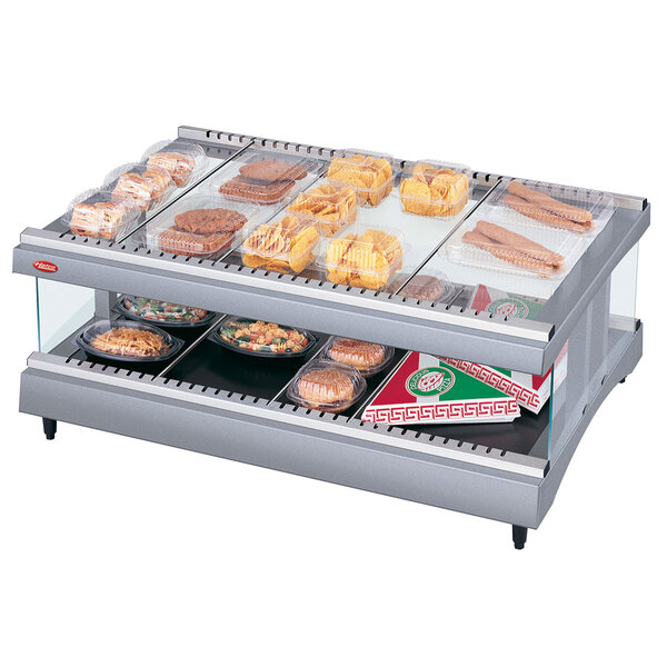 A Hatco countertop heated glass display case with food on a shelf.