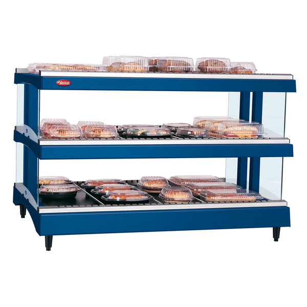 A navy blue Hatco heated glass merchandising warmer with double shelves holding food.