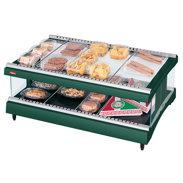 A Hunter green Hatco heated glass food display shelf with trays of food.