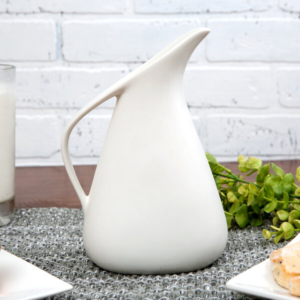 A white 10 Strawberry Street Whittier porcelain milk jug on a table.