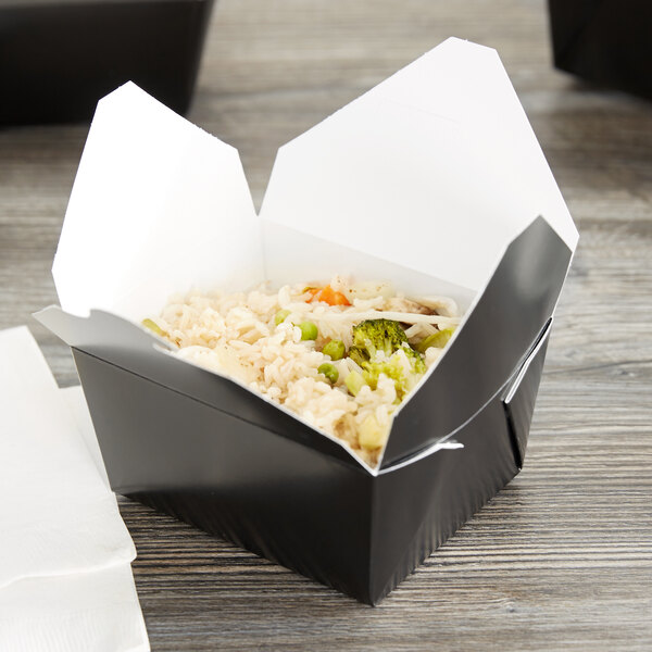 A black Fold-Pak Bio-Pak take-out box filled with rice and vegetables.
