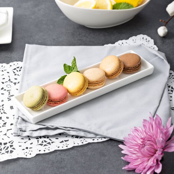 A 10 Strawberry Street white rectangular porcelain dish filled with macarons on a table in a brunch café.