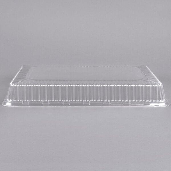 A Durable Packaging clear plastic dome cover on a gray surface.