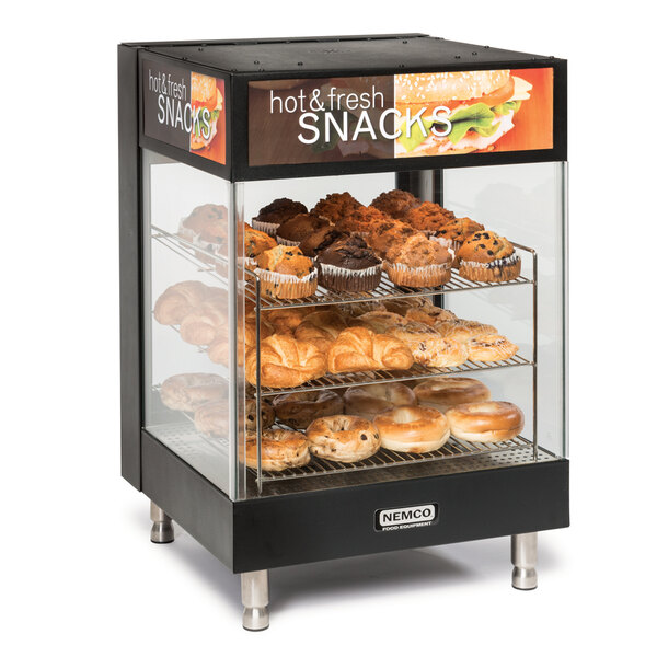 A Nemco countertop hot food display with pastries on shelves.