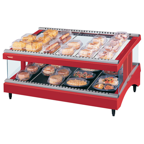 A Hatco red slanted heated glass display case with food on trays.