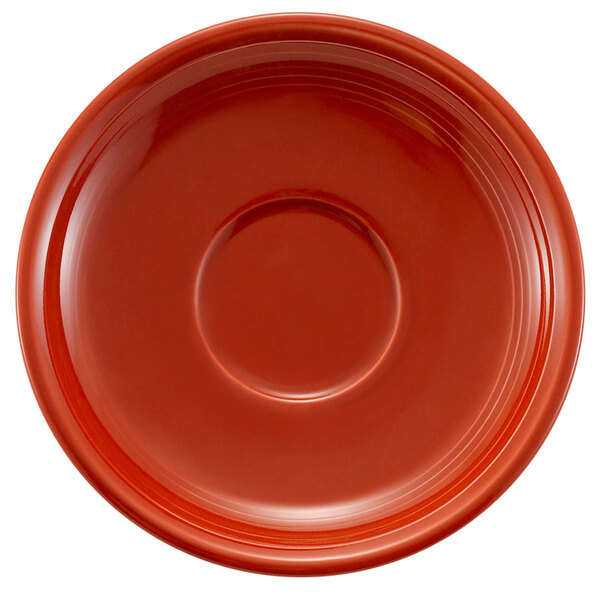 A red round saucer with a circle in the middle.