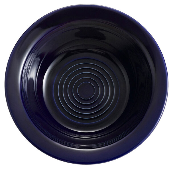 A cobalt blue bowl with a spiral pattern on the rim.