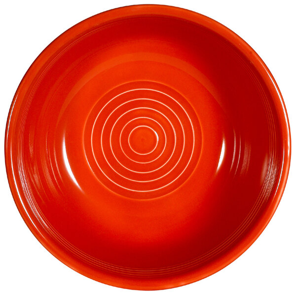 A red CAC China bowl with a spiral pattern.
