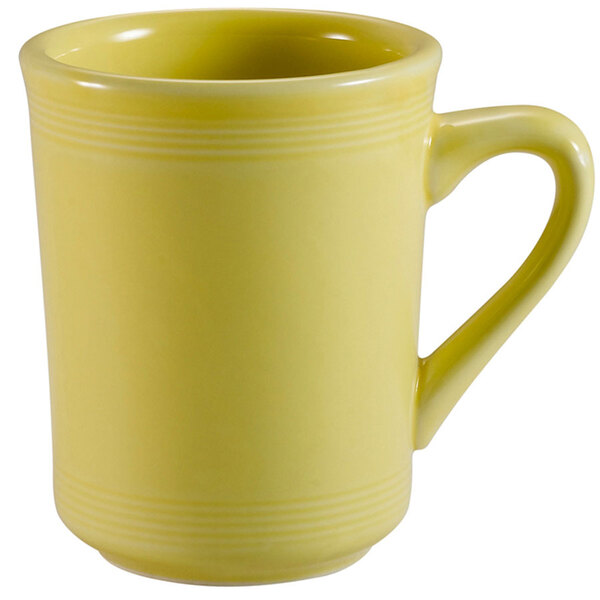 A close-up of a yellow CAC sunflower mug with a handle.