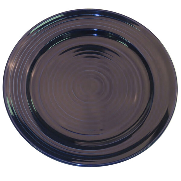 A cobalt blue round plate with a spiral pattern.