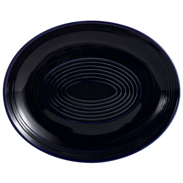 A cobalt blue oval platter with a spiral design on it.