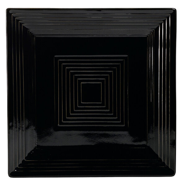 A black square porcelain plate with a geometric design.