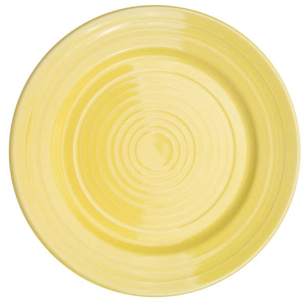 A yellow porcelain plate with a white sunflower design in the center.