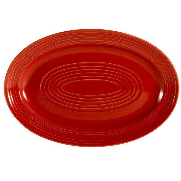A red oval CAC China platter with a circular design.