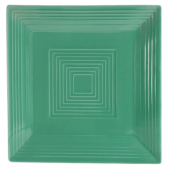A close-up of a square green plate with white lines on it.
