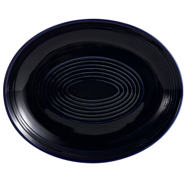 A cobalt blue oval platter with a spiral design in the center.