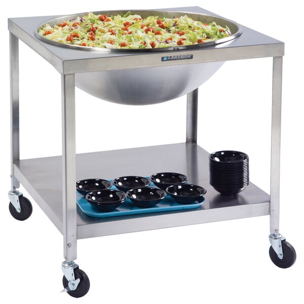 A Lakeside mobile mixing bowl stand with a large stainless steel bowl of salad on top.