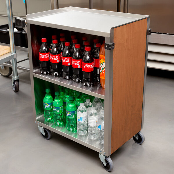 A Lakeside metal utility cart with bottles of soda and water on it.