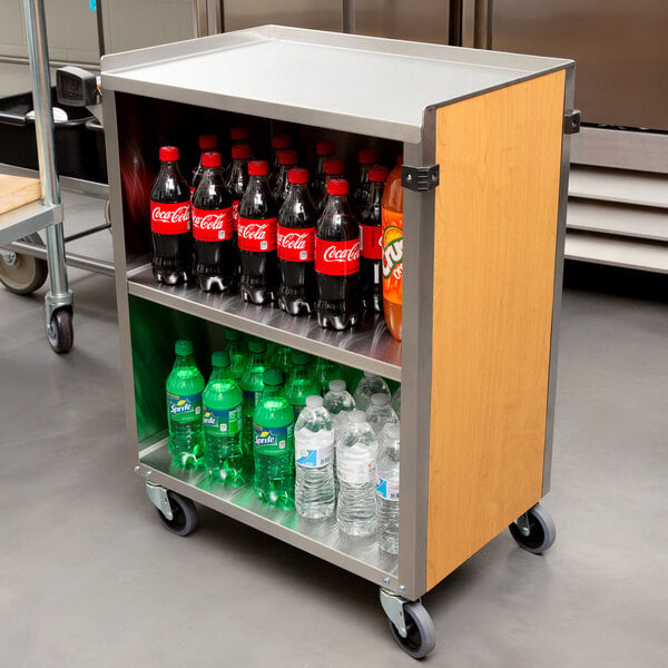 A Lakeside metal utility cart with bottles of soda and water on it.