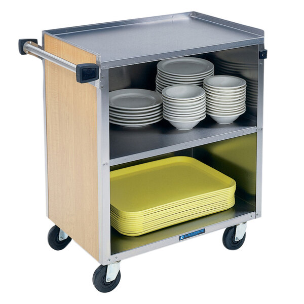 A Lakeside stainless steel utility cart with light maple shelves holding yellow plastic plates.