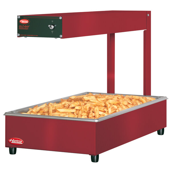 A red Hatco Glo-Ray food warmer with french fries in a large rectangular container.