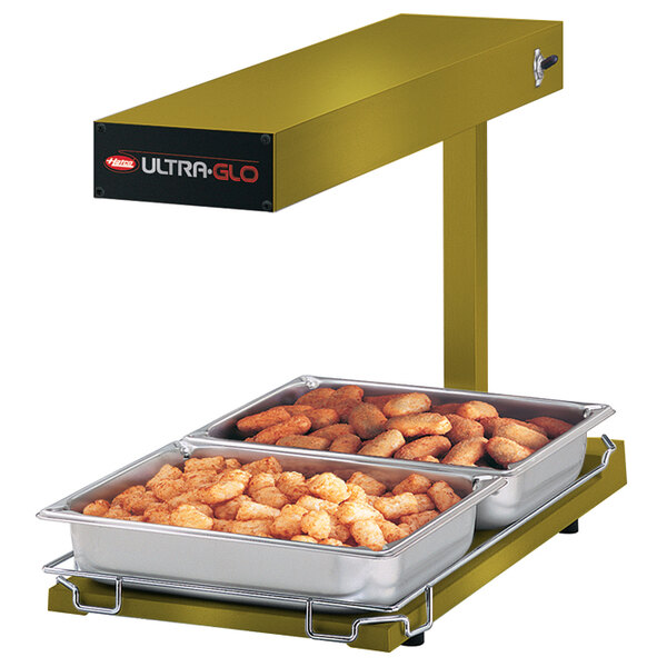 A Hatco Ultra-Glo food warmer with trays of tater tots on a counter.