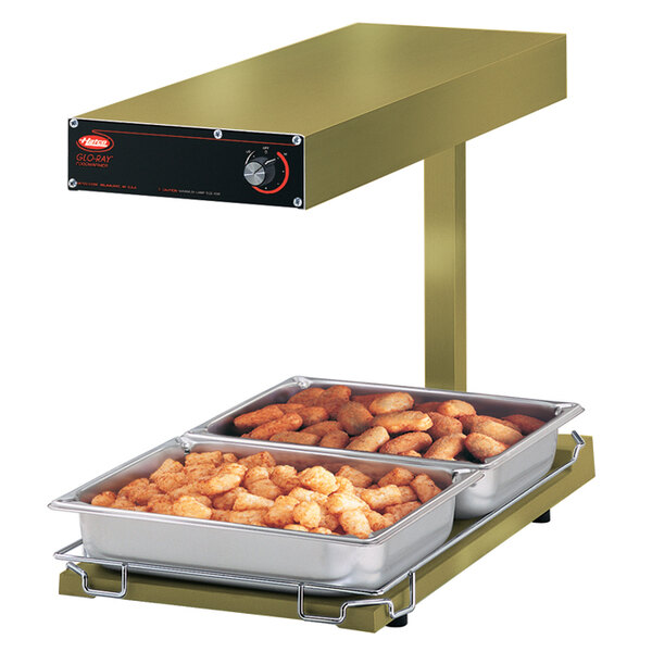 A Hatco portable food warmer with trays of tater tots on it.