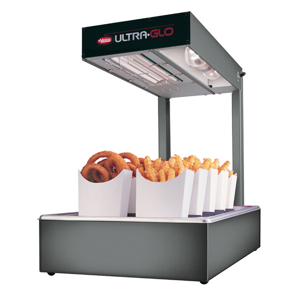 A Hatco Ultra-Glo food warmer with fries and onion rings on a counter.